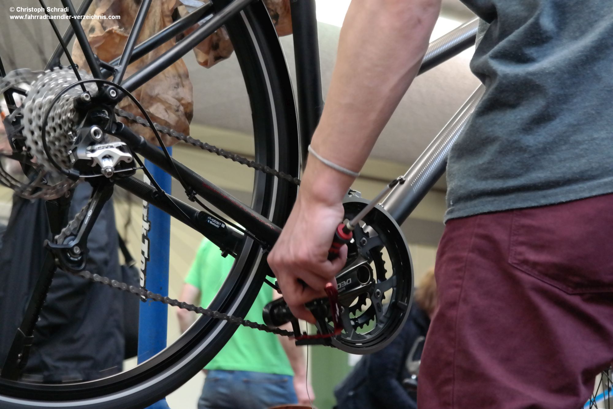 Ein Zweiradmechatroniker der Fachrichtung Fahrrad überprüft die korrekte Einstellung einer Kettenschaltung